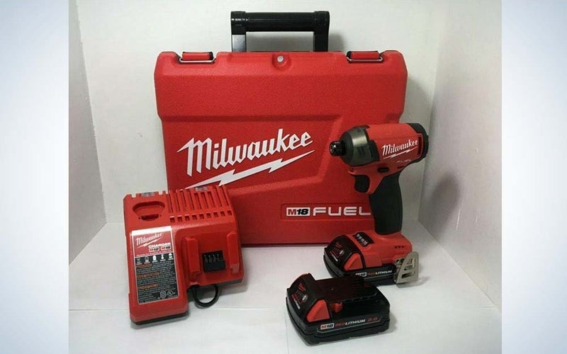 A red Milwaukee tool bag with an impact driver, battery, and battery charger in the foreground.