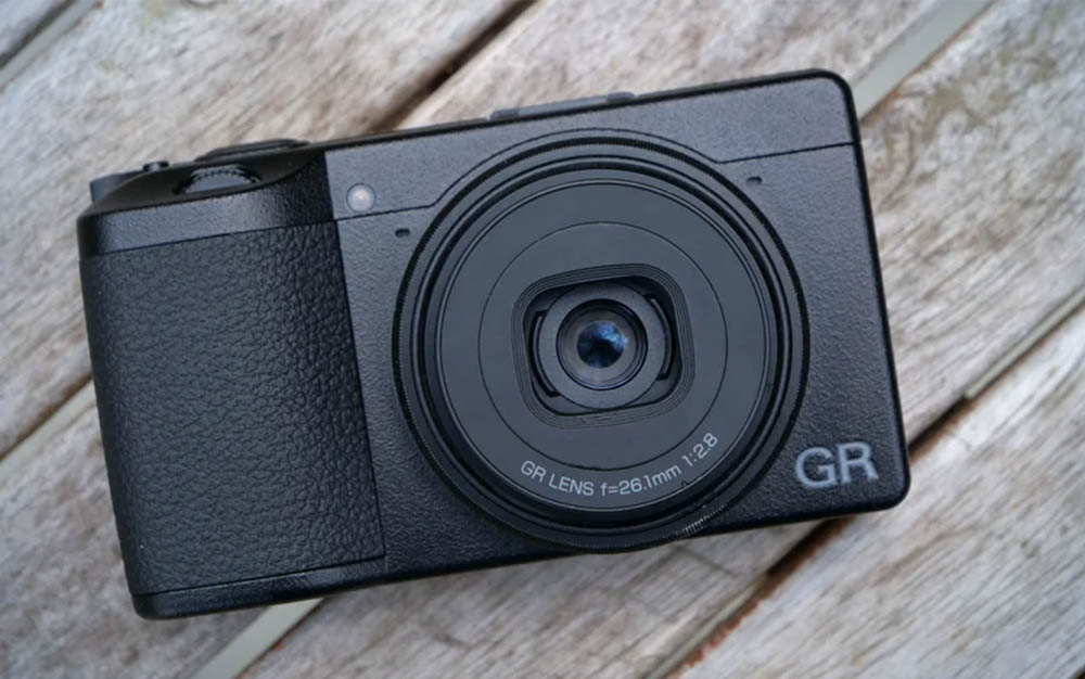 Black Ricoh GR IIIx on a wooden surface