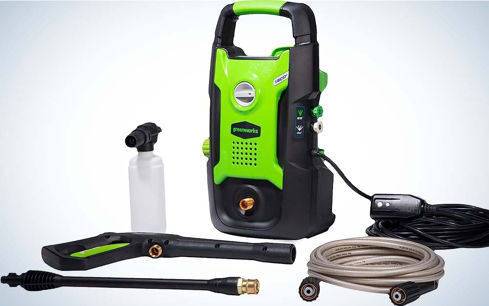 A green and black pressure washer by Greenworks with a black cord, water bottle, and hose in the foreground.