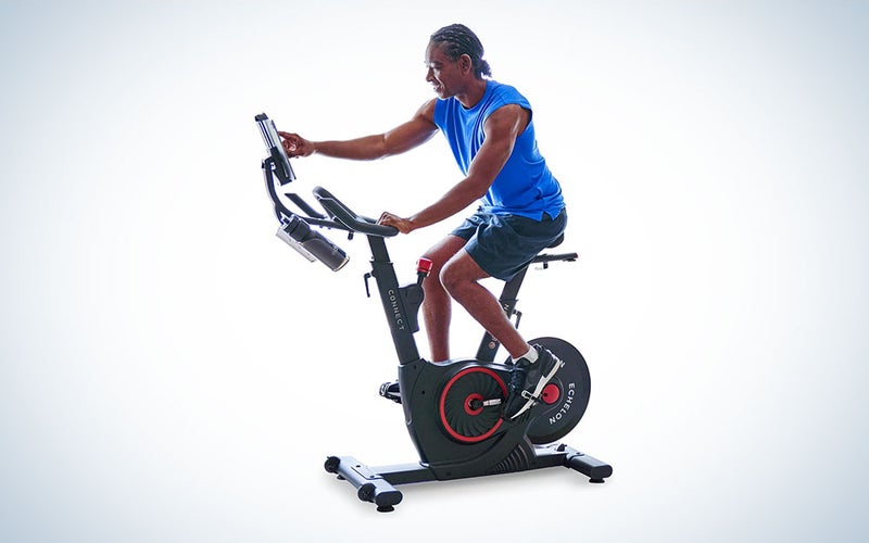 A person riding a Echelon Smart Connect Fitness Bike on a plain background