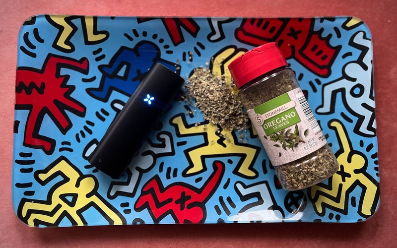 A Pax Plus cannabis vaporizer on a rolling tray with some oregano seasoning