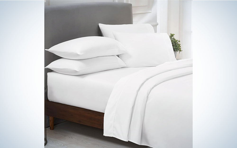 A pair of white California Design Den sheets on a bed
