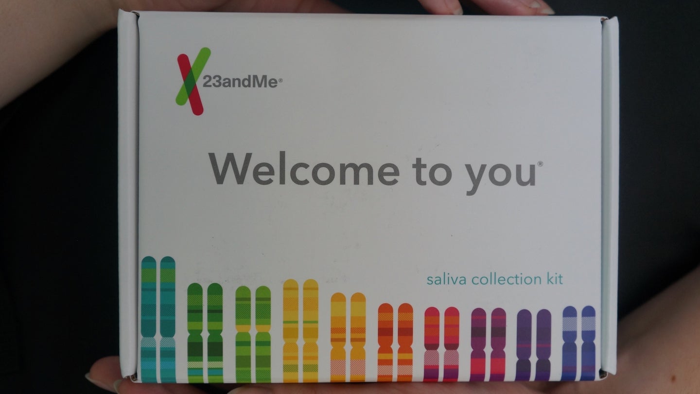 Woman's hands holding 23andMe saliva testing box