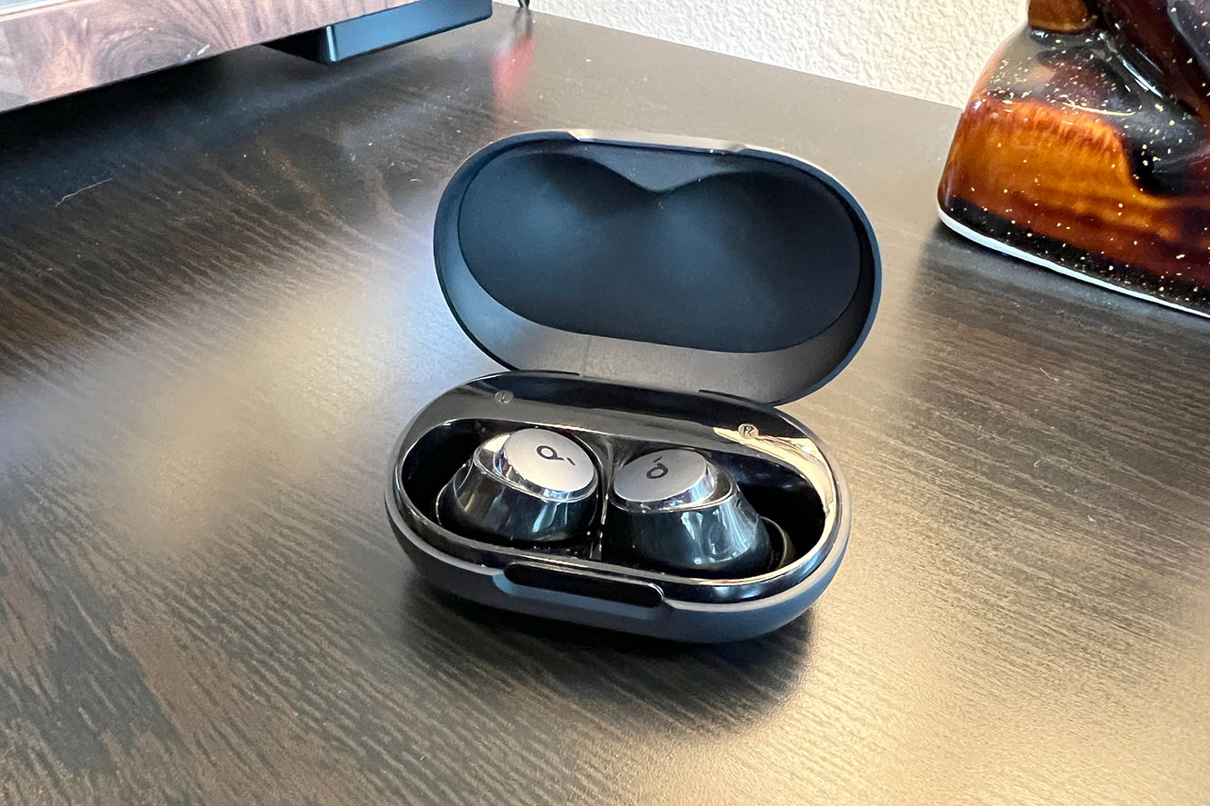 Black Soundcore by Anker A40 earbuds for small ears in their case on a wood table