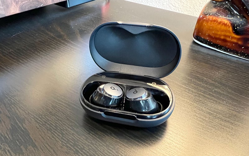 Black Soundcore by Anker A40 earbuds for small ears in their case on a wood table