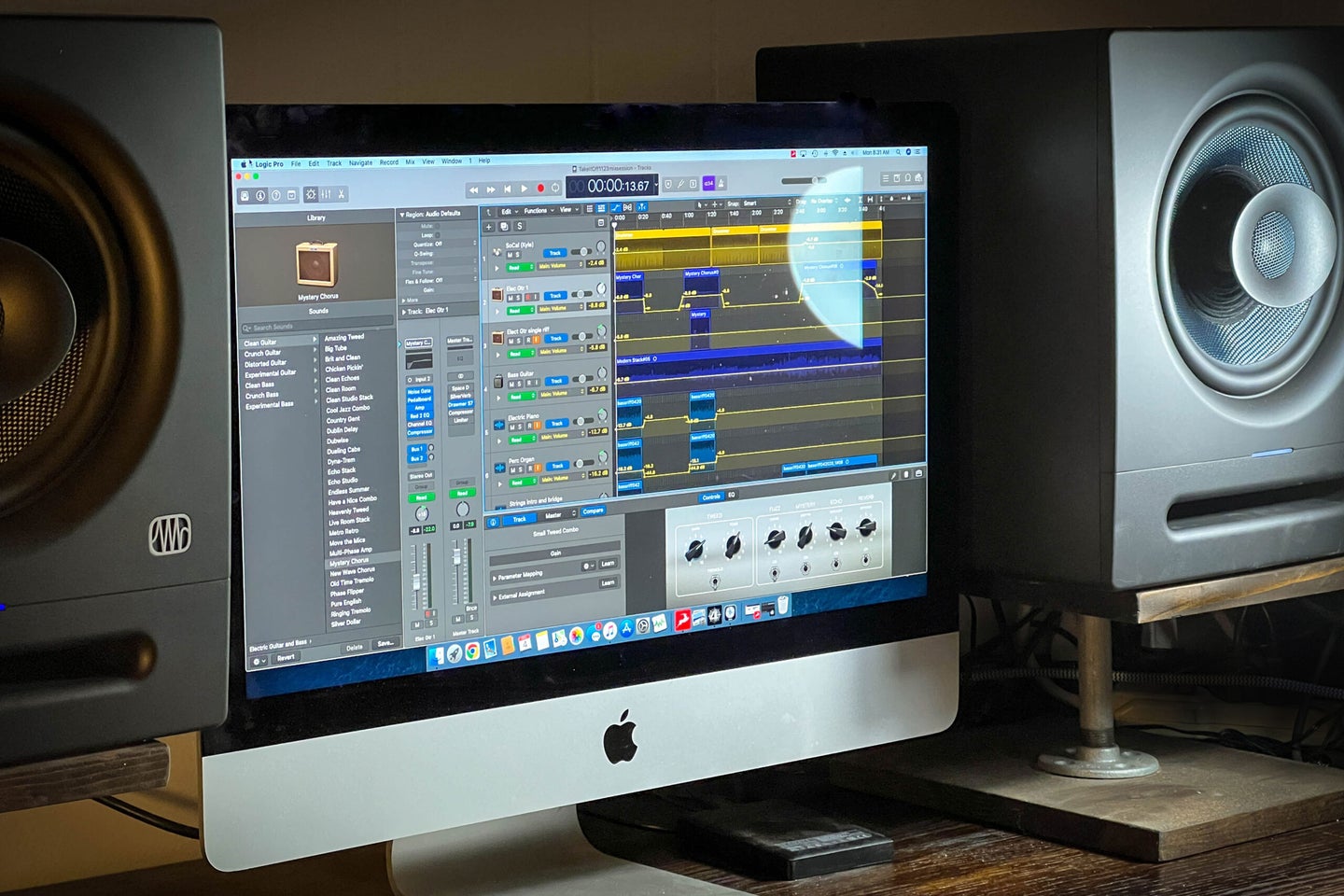 Two Eris Pro 8 studio monitors flanking a Mac desktop computer with a digital audio workspace open.