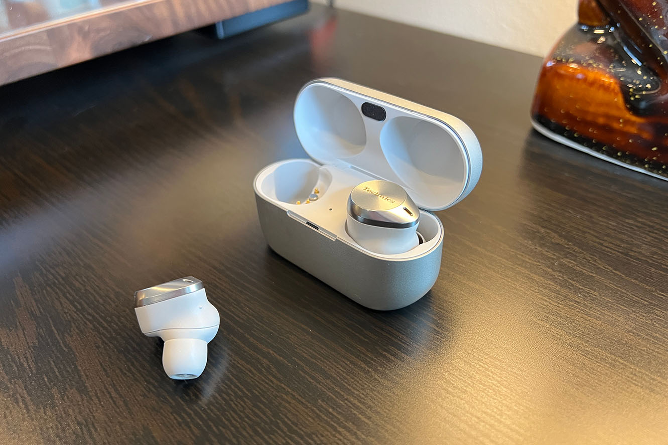 White and silver Technics AZ80 earbuds for small ears on a wood table