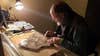 Martin Lockley sits at an illuminated desk tracing fossil tracks.
