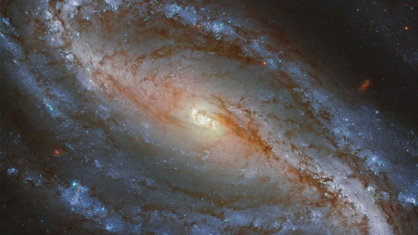 NGC 613 is a galaxy in the southern constellation of Sculptor, about 67 million light-years away. In this image from the NASA/ESA Hubble Space Telescope, NGC 613 is an example of a barred spiral galaxy. It is easily distinguishable as such because of its well-defined central bar and long arms, which spiral loosely around its nucleus. About two-thirds of spiral galaxies, including our own Milky Way galaxy, contain a bar. 
