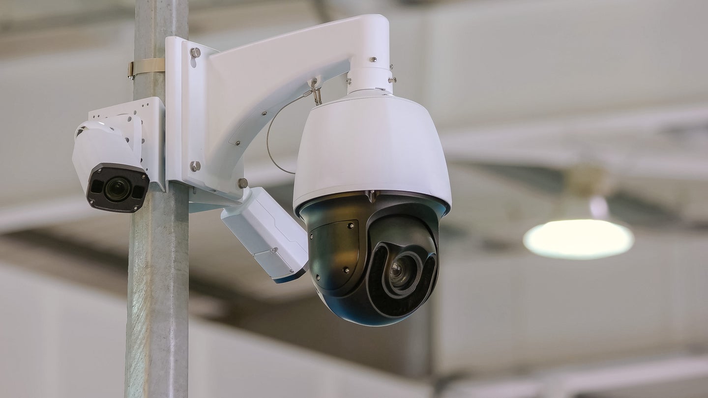 Rotating black surveillance control camera indoors