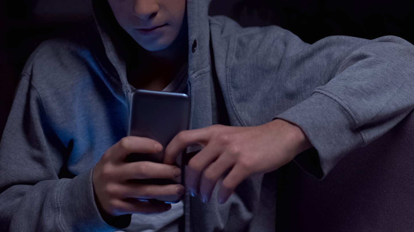 Teen using phone at night after curfew