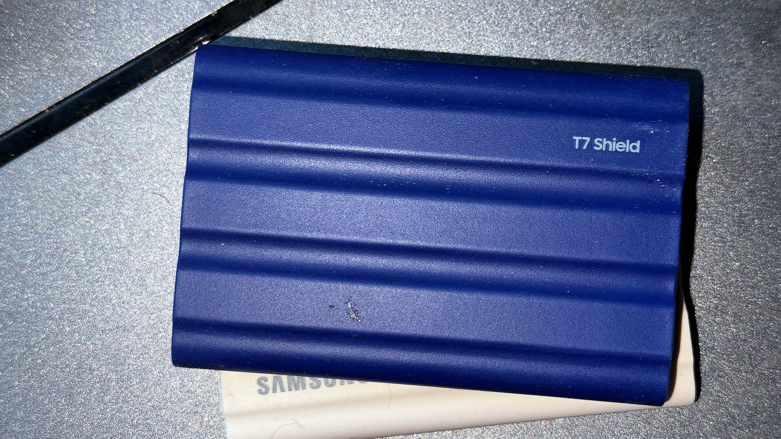 Samsung T7 Shield portable SSD sitting on top of a scanner