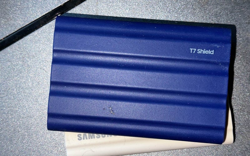 Samsung T7 Shield portable SSD sitting on top of a scanner