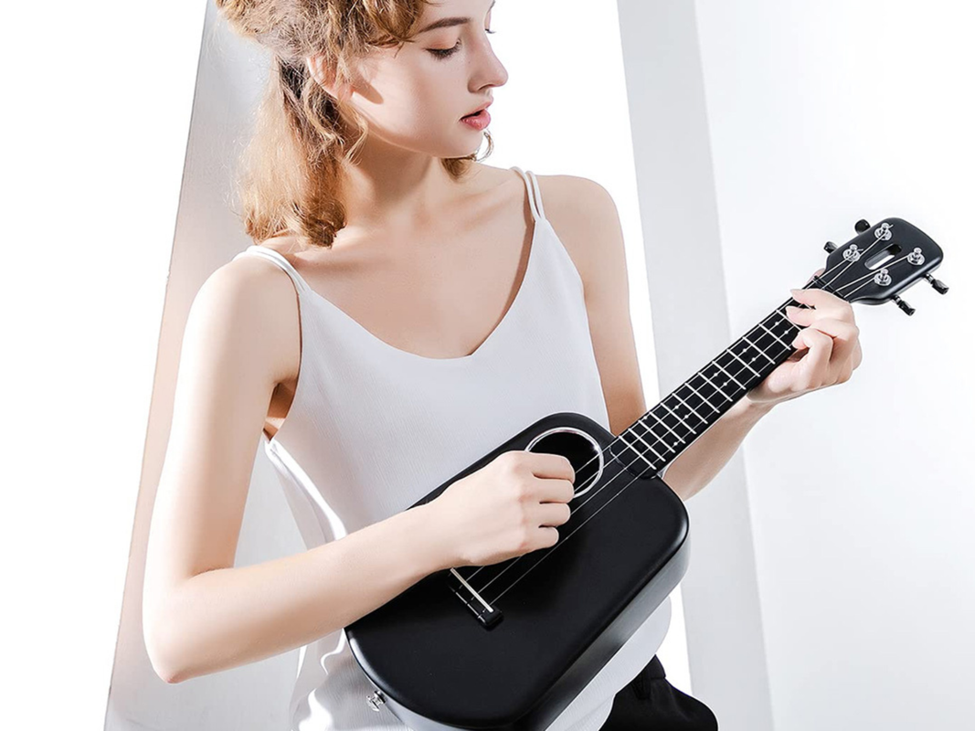 A person playing a smart ukelele.