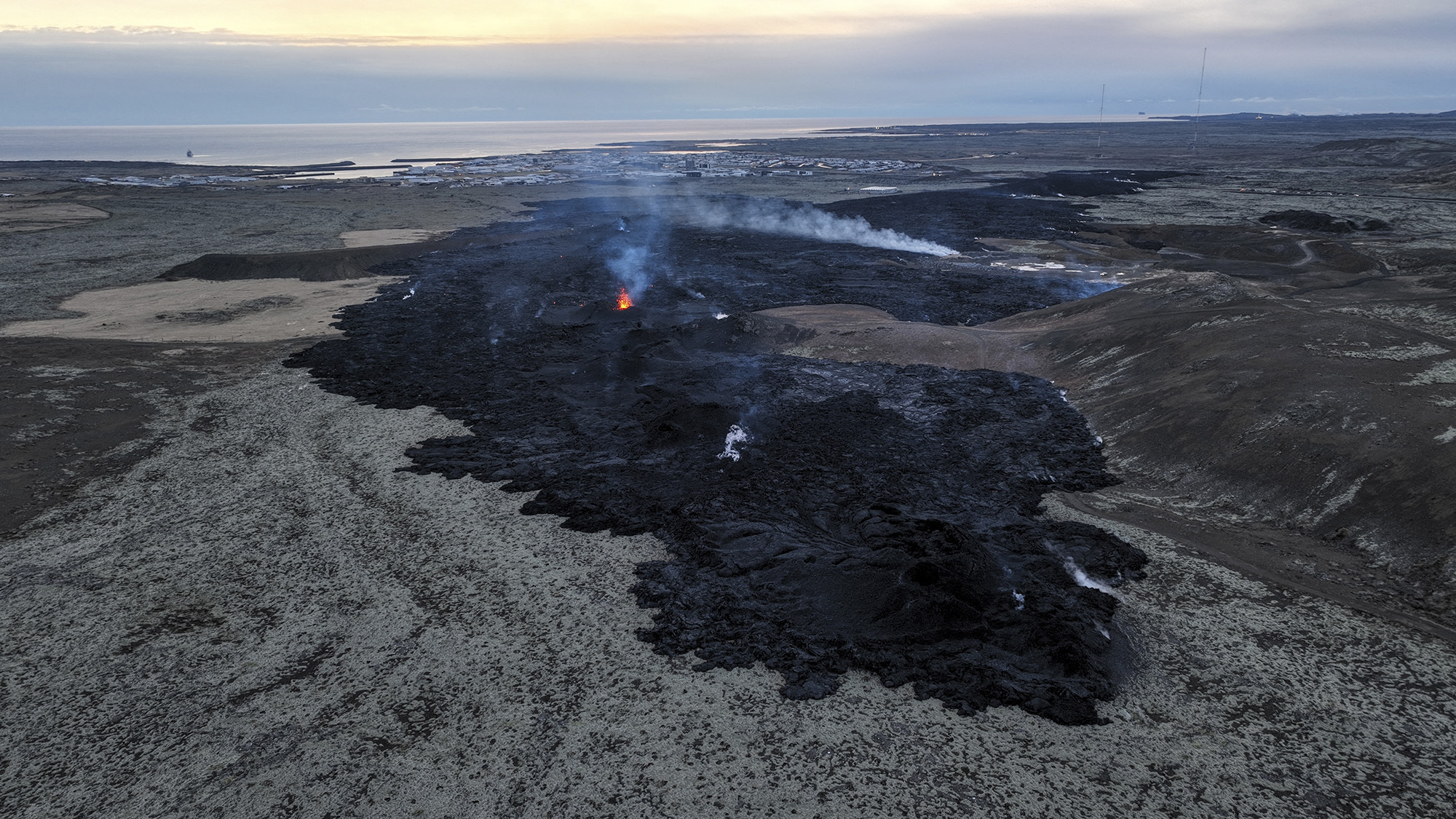 An aerial view taken on January 15, 2024 shows volcanic activity near Grindavík after an eruption. According to authorities, volcanic activity in southwest Iceland appears to have eased, one day after lava from an eruption flowed into the fishing town, engulfing several homes.