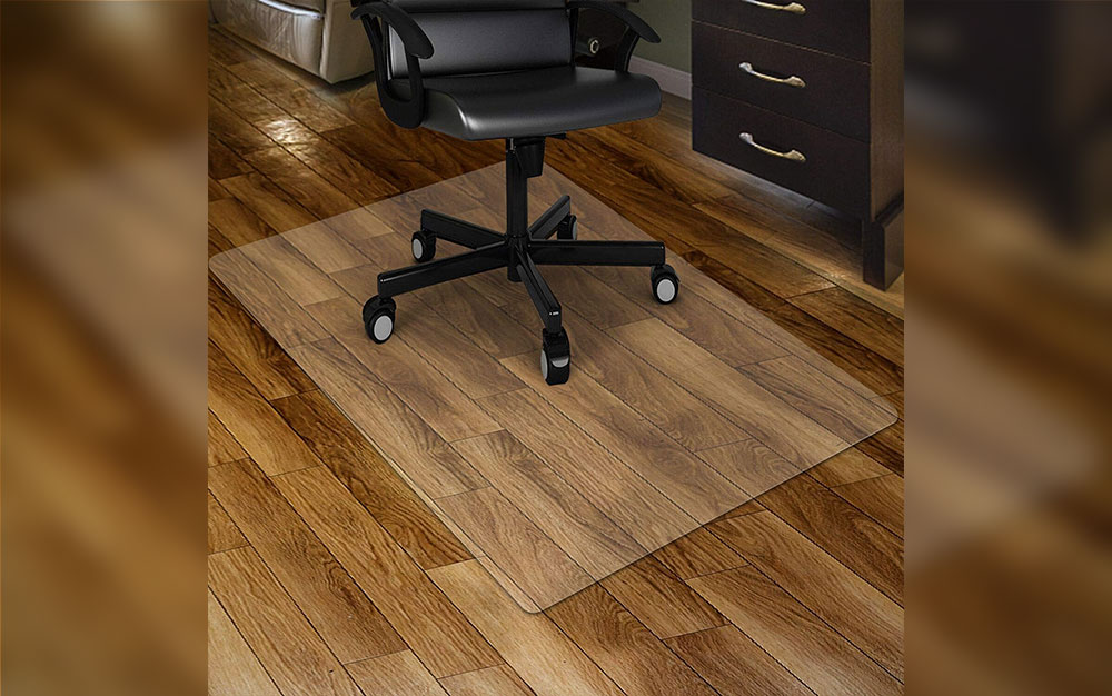 A Kuyal Clear budget Chair Mat on a brown vinyl floor