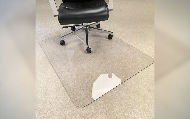 A MuArts alternative Chair Mat on a tan carpet with a desk chair on top.
