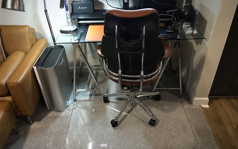 A Vitrazza Glass Office Chair Mat on a tan carpet.