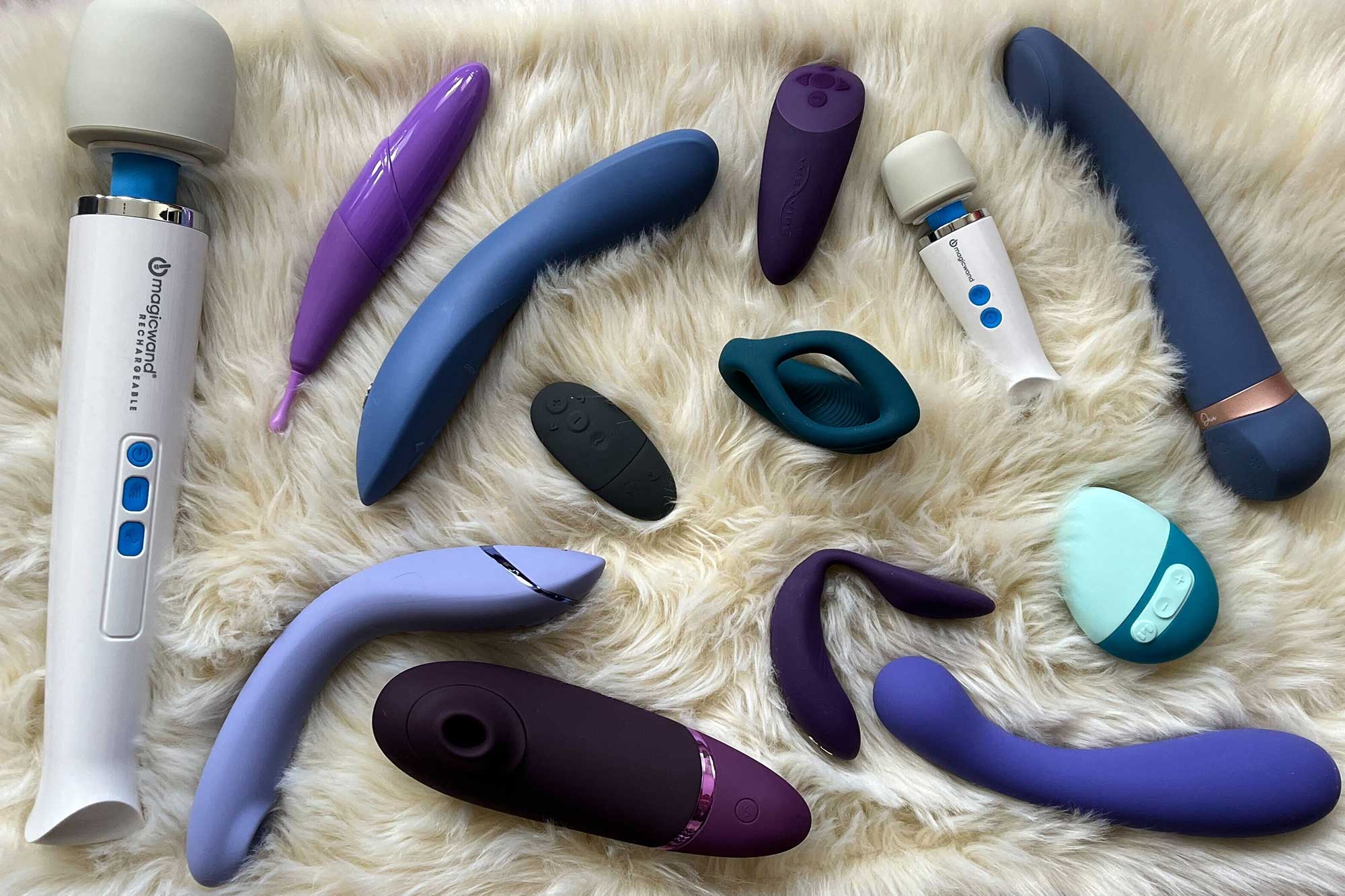 An array of the best sex toys for couples on a white fuzzy carpet.