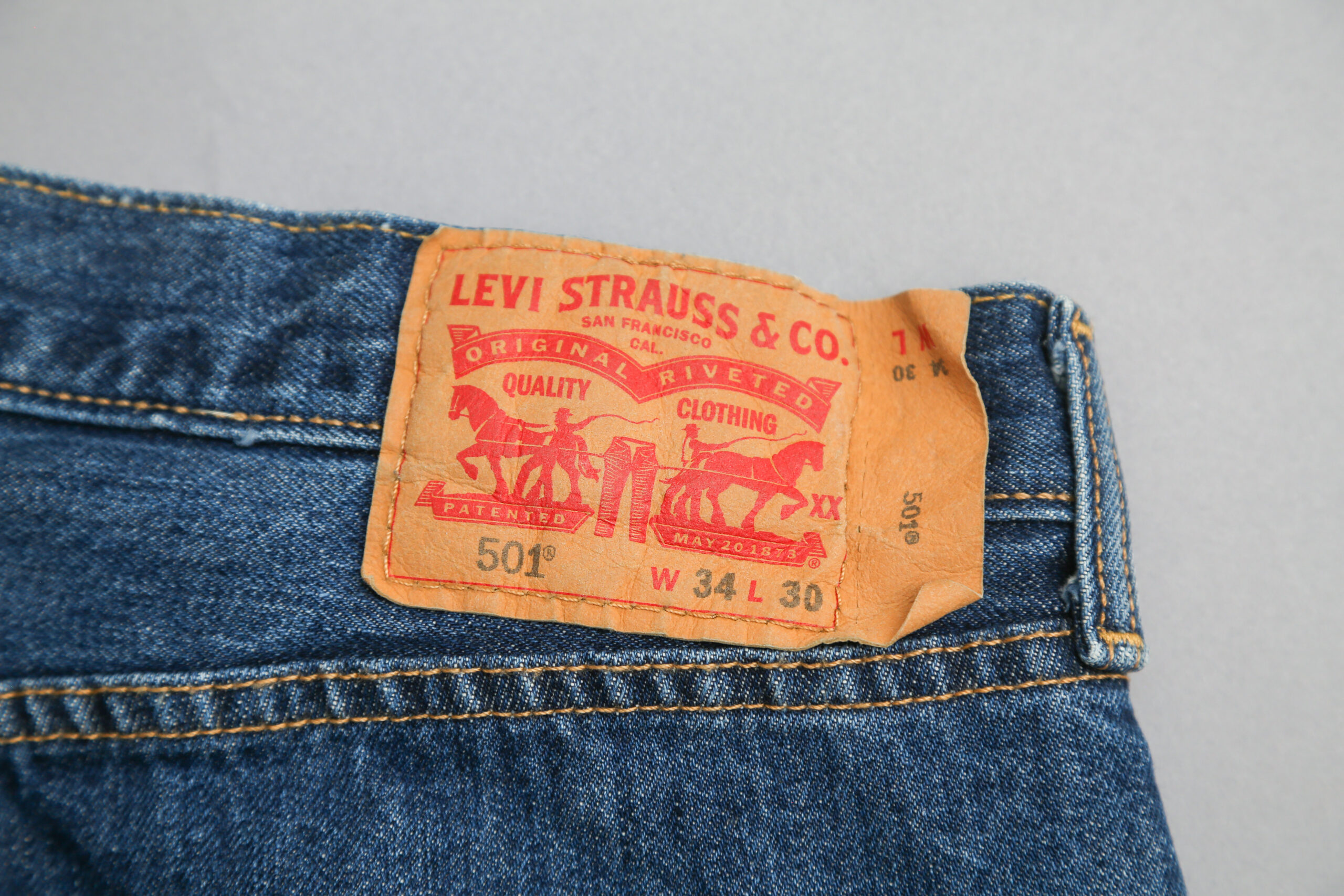 Levi's 501 tag on a pair of jeans on a plain background