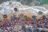 Overhead perspective above a beach filled with people and fish baskets