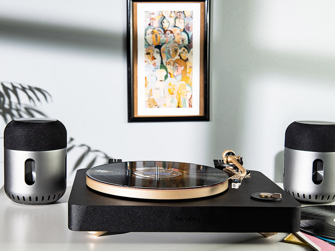 A turntable flanked by two Kapsule wireless speakers