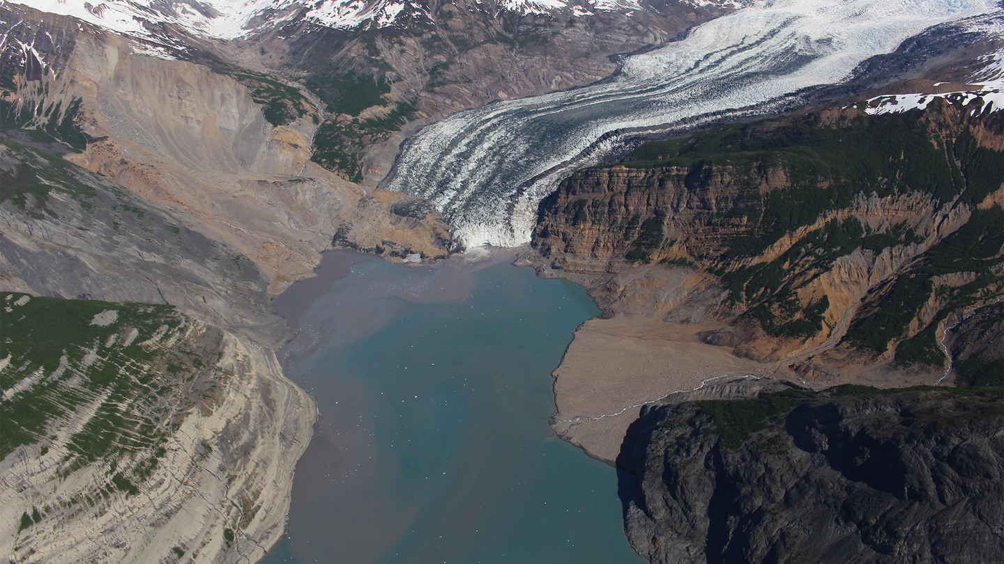 A photograph taken in the spring of 2016 of the debris field from an October 2015 landslide extends over the toe of the Tyndall Glacier and into Taan Fjord.