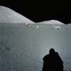 the shadow of an astronaut is seen in front of lunar vehicles
