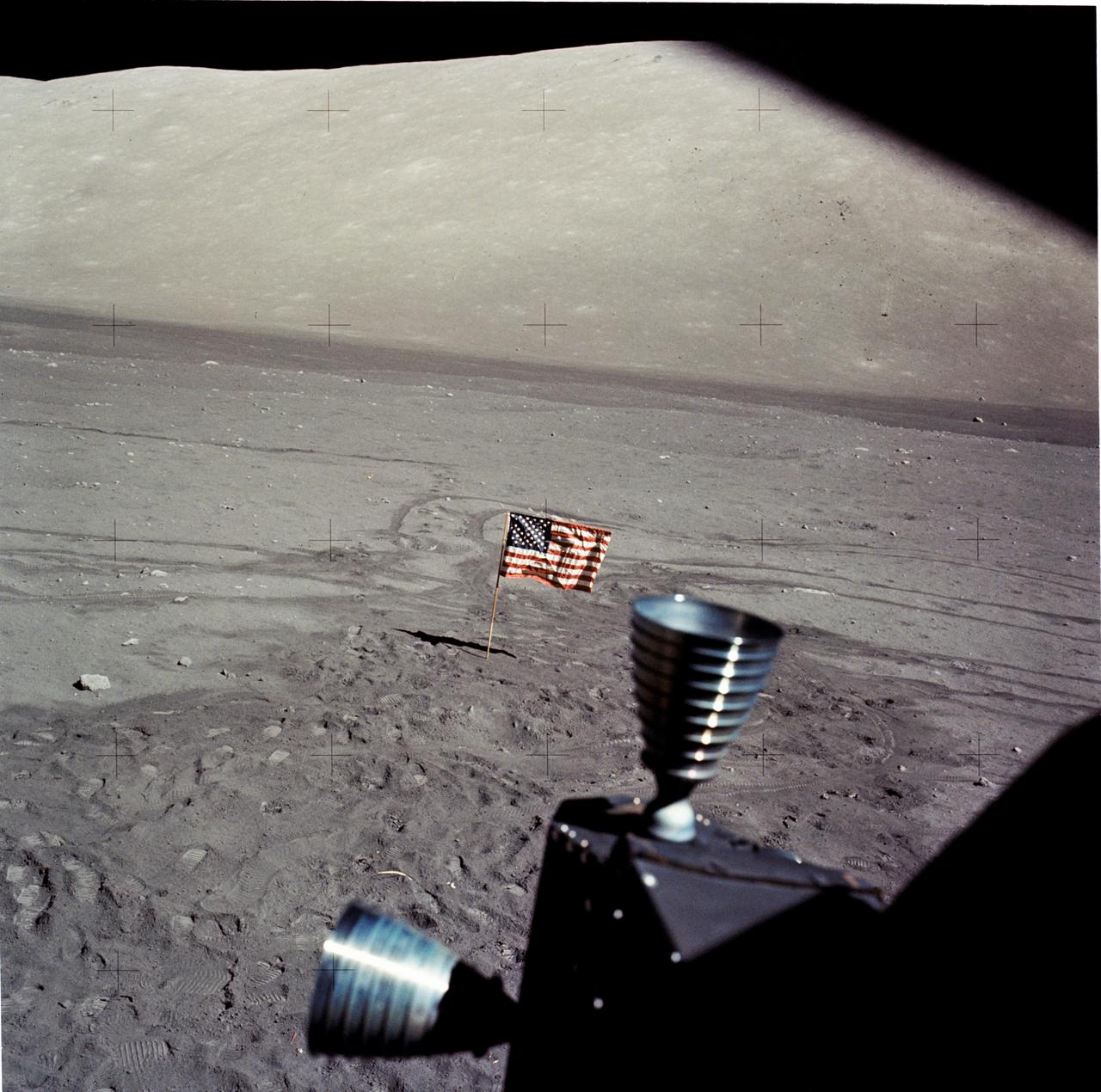 an american flag on the surface of the grey, dusty moon