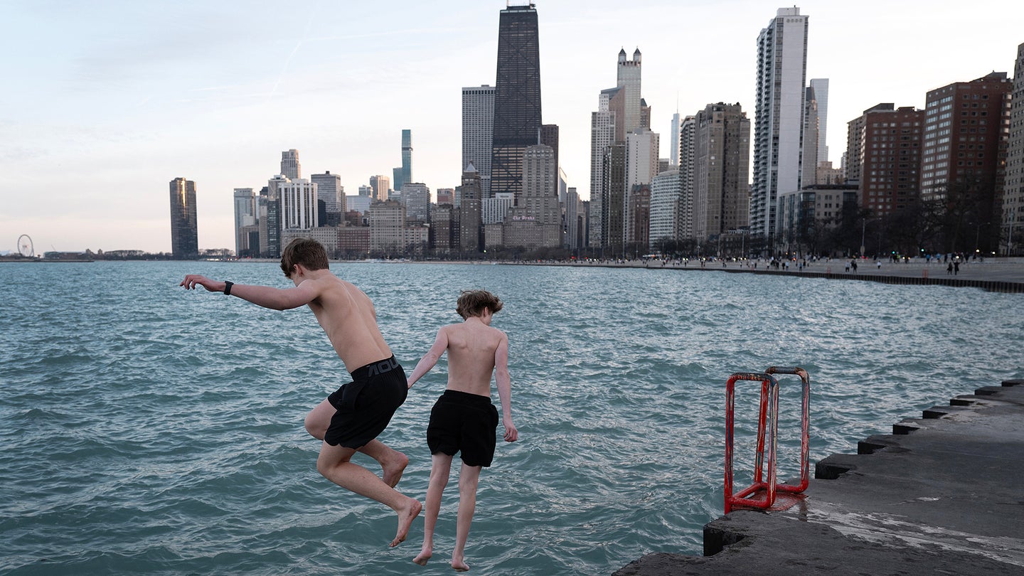 Ryan Ahmadian and Mack Brusznicki jump into Lake Michigan as temperatures climbed to 71 degrees on February 26, 2024 in Chicago, Illinois. The unusually warm day broke a previous high record of 64 degrees, set in 2000. Snow is expected on Wednesday. 