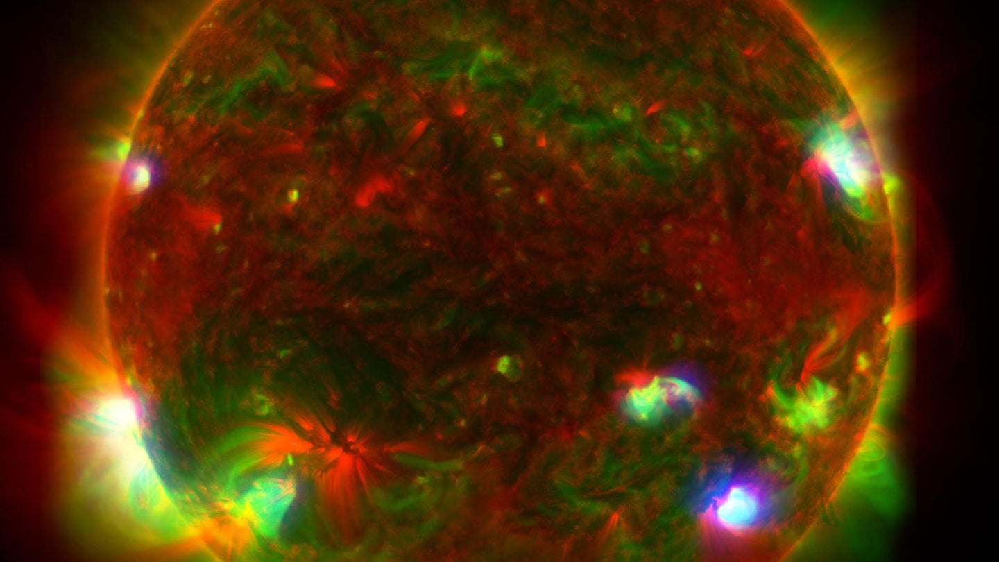 This composite image of the Sun includes high-energy X-ray data from NASA's Nuclear Spectroscopic Telescope Array (NuSTAR) shown in blue; lower energy X-ray data from the X-ray Telescope (XRT) on the Japanese Aerospace Exploration Agency's Hinode mission shown in green; and ultraviolet light detected by the Atmospheric Imaging Assembly (AIA) on NASA's Solar Dynamics Observatory (SDO) shown in red.