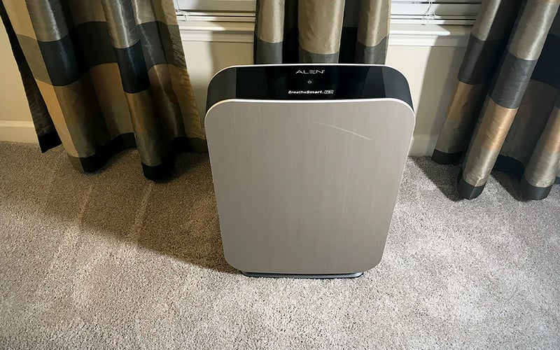 Silver rectangular Alen BreathSmart 75i air purifier on carpet in front of curtains