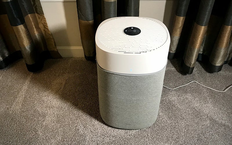 White grey round BlueAir Pure 211i Max air purifier on carpet in front of curtains