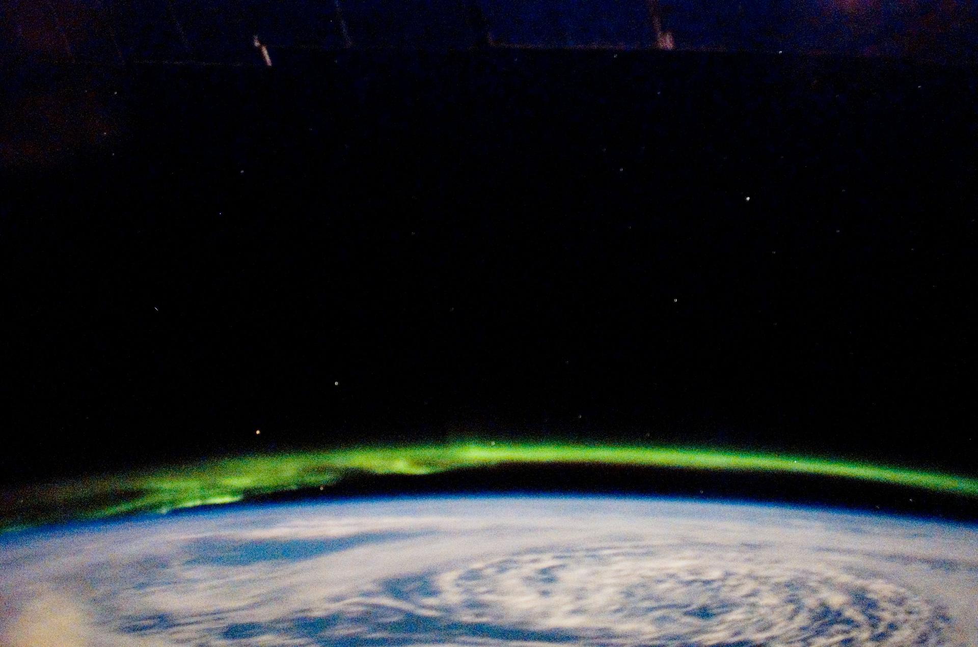 green aurora over a cloudy earth