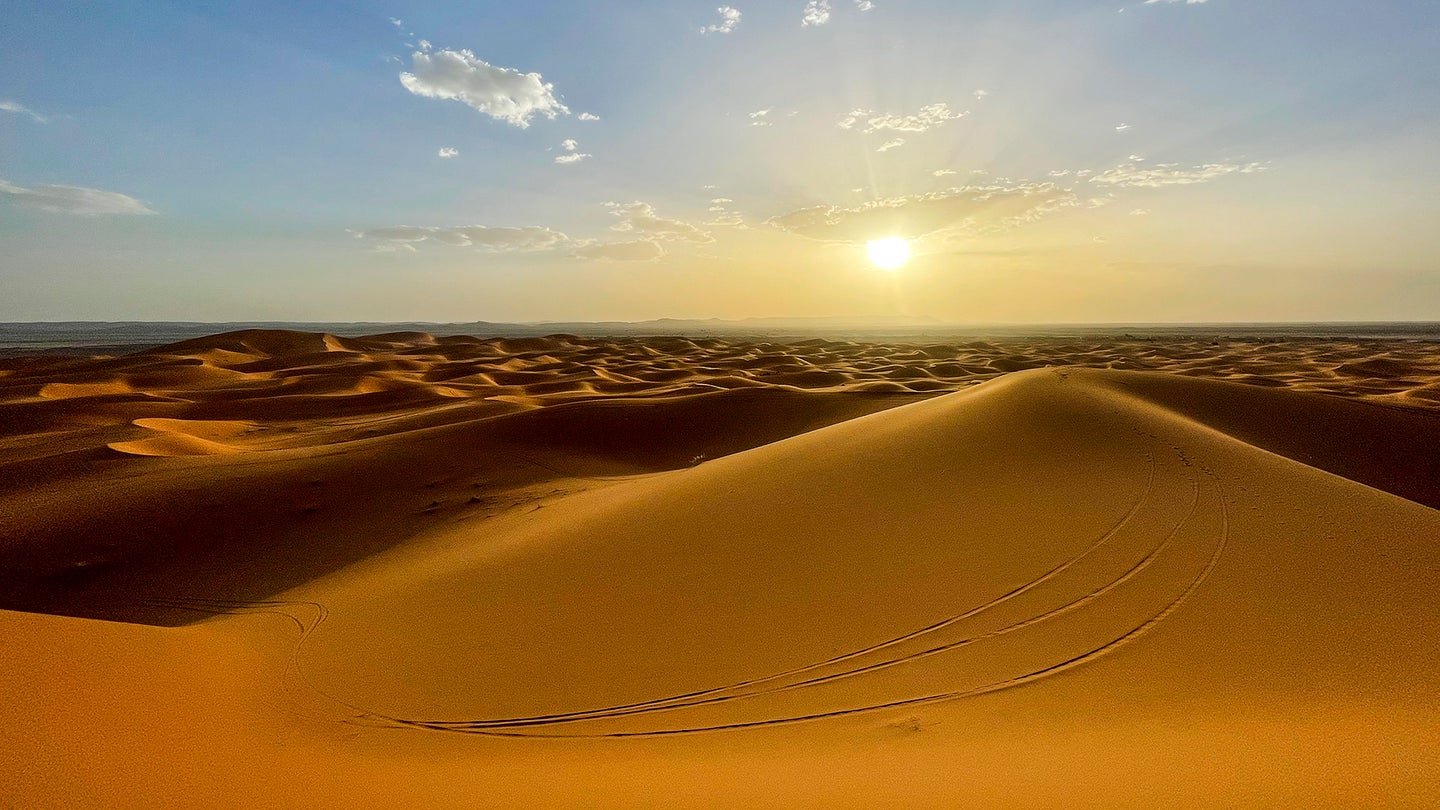 Sun rises over tall sand dunes. The Erg Chebbi region of the Sahara desert in Morocco. The region is home to the 984 foot tall Lala Lallia star dune.