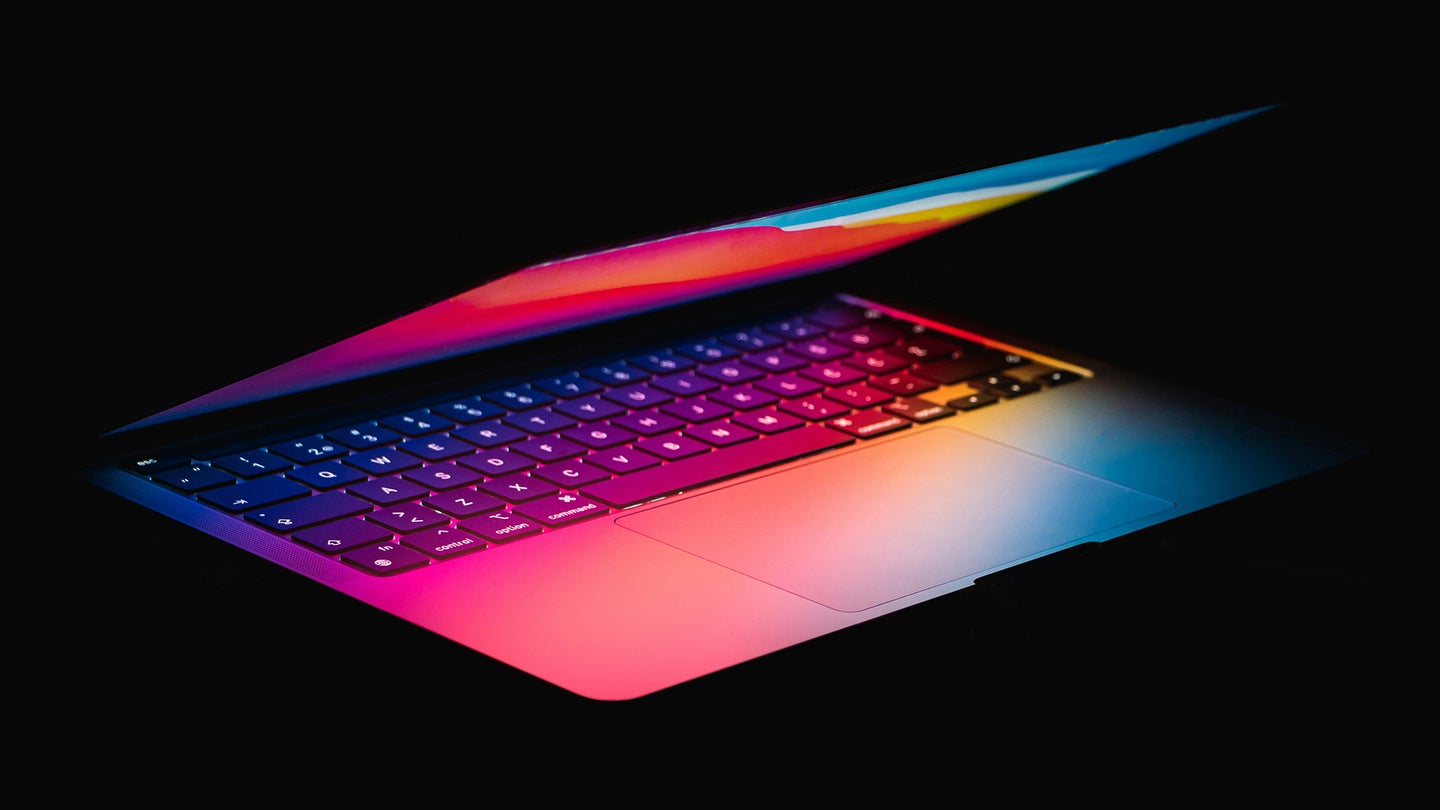 an almost-closed laptop with glowing rainbow light