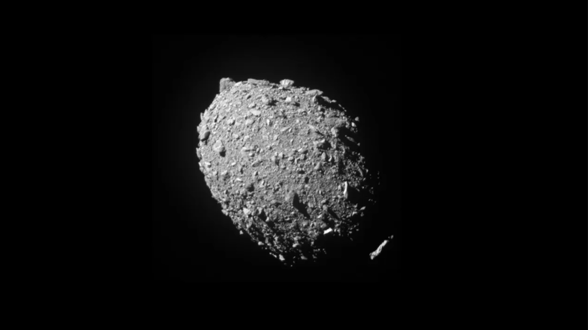 A circular asteroid with a smaller rock orbiting it. The asteroid Dimorphos was captured by NASA’s DART mission just two seconds before the spacecraft struck its surface on September 26, 2022.