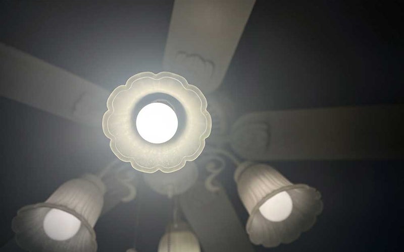 A Sylvania LED light bulb in a ceiling fan light socket.