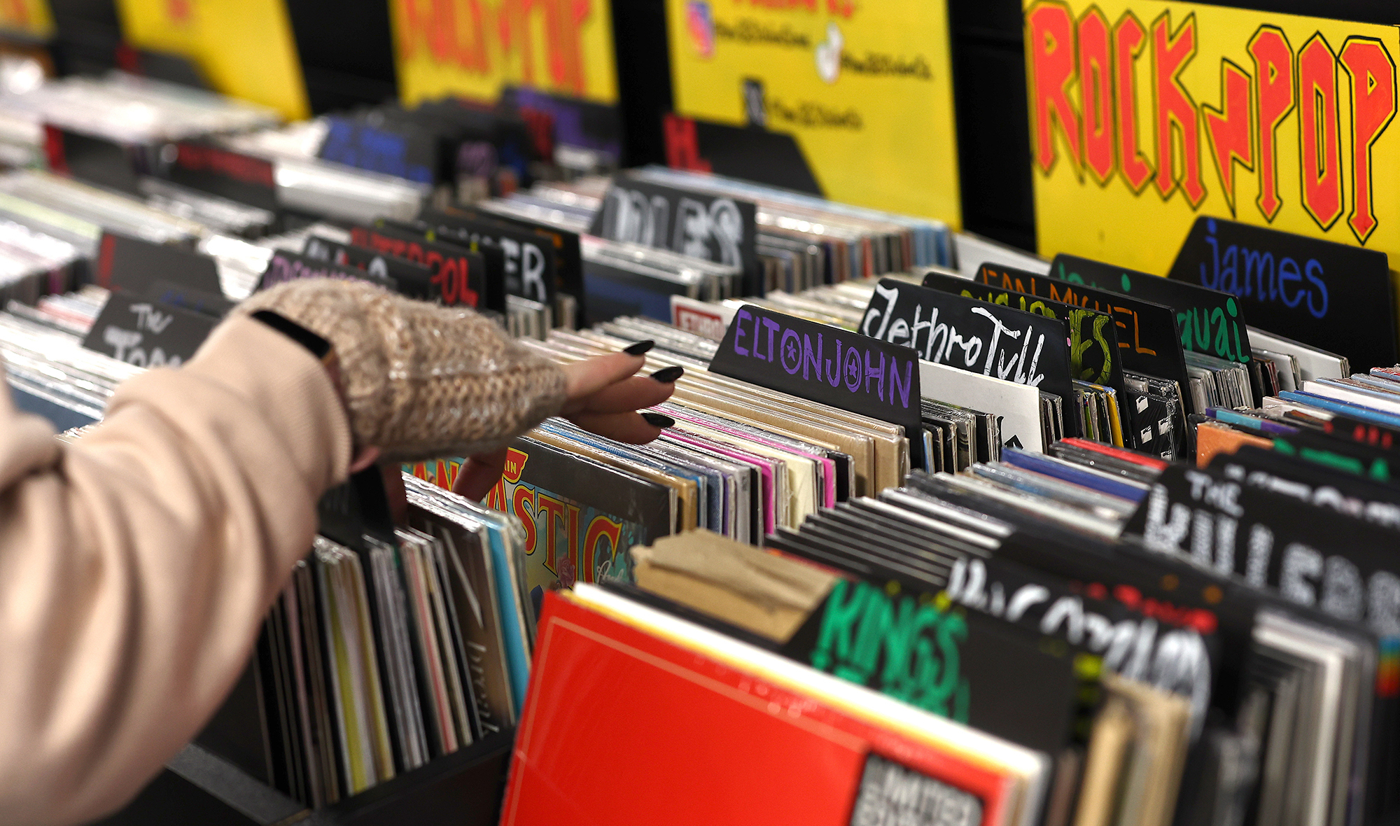 Hand flipping through vinyl records at store