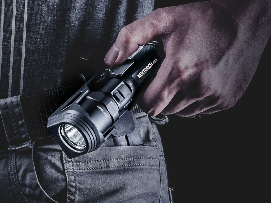 A person holding a black flashlight.