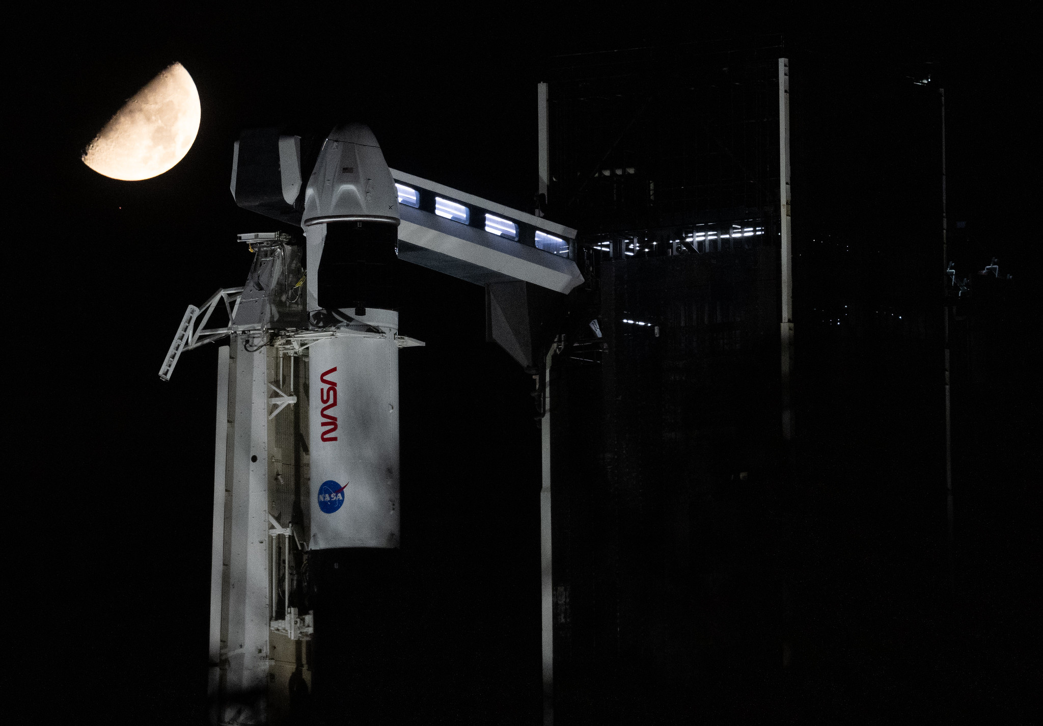 a spacecraft reading "NASA" at night with a dark sky and bright moon
