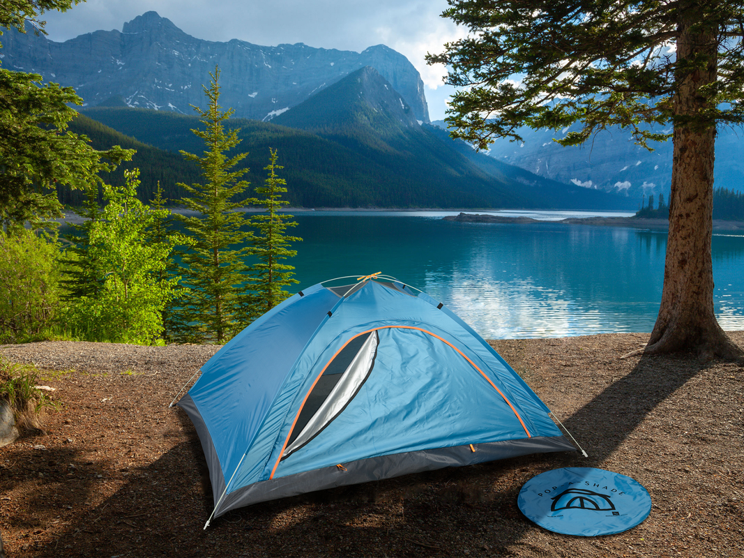 A Pop-A-Shade tent set up outdoors by a lake.
