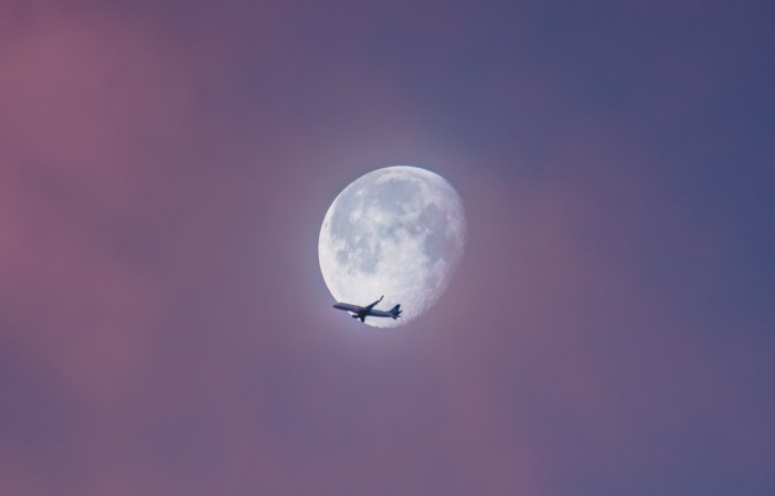 Commercial airplane flying across almost full moon. The question is: Are long flights safe?