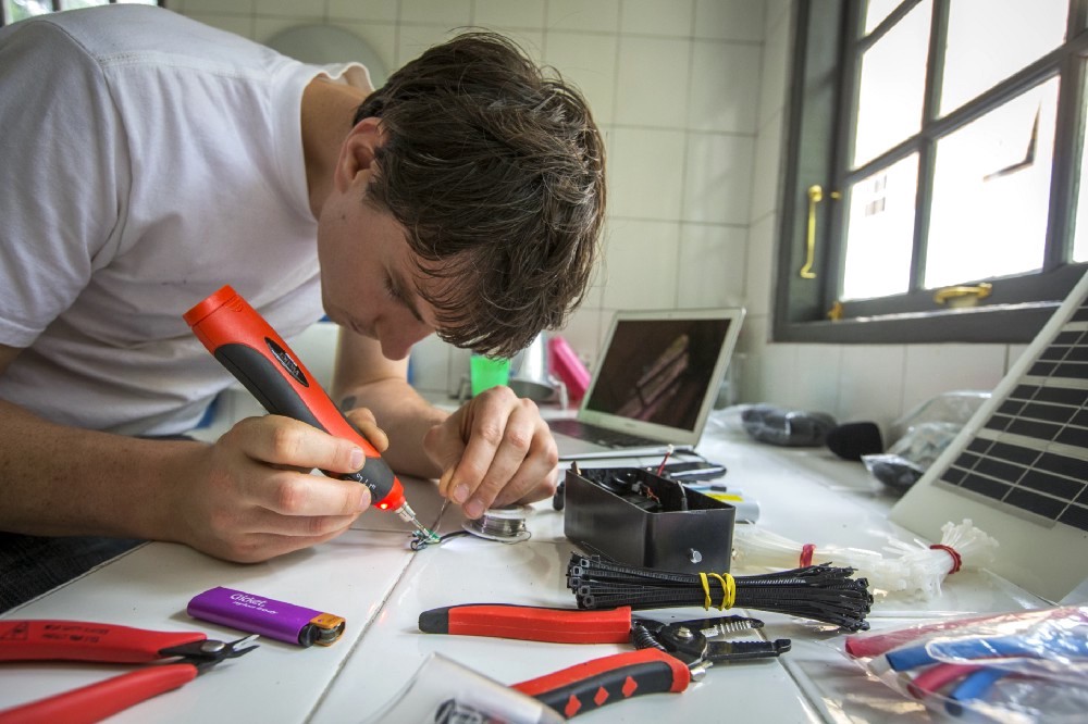 White assembles a cell phone listening device.