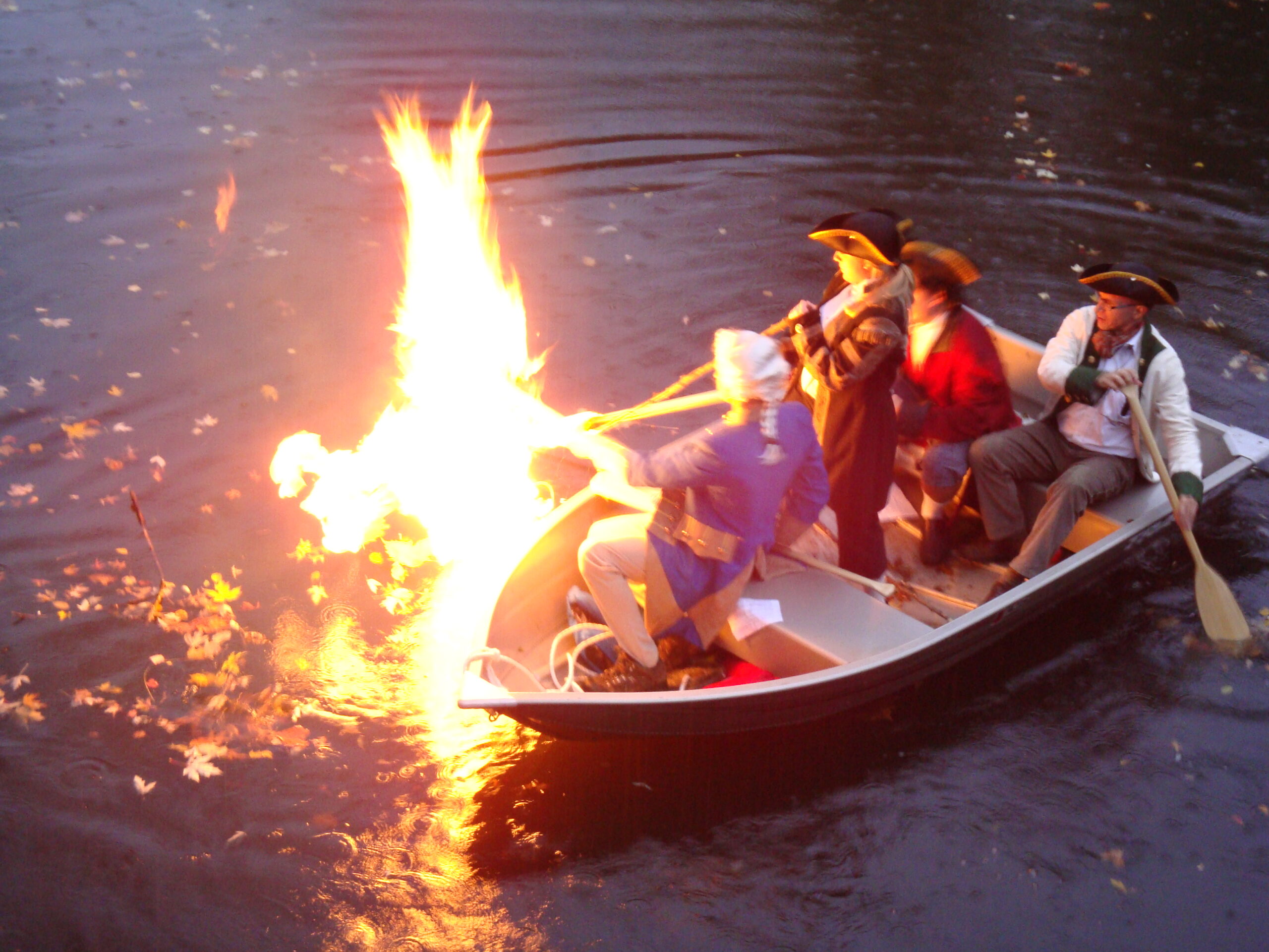 men in Revolutionary War clothing light marsh gas on fire