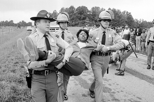 A woman is carried away by police during a protest.