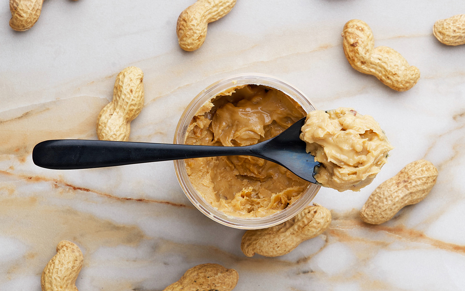 Spoonful of peanut butter on a jar of peanut butter