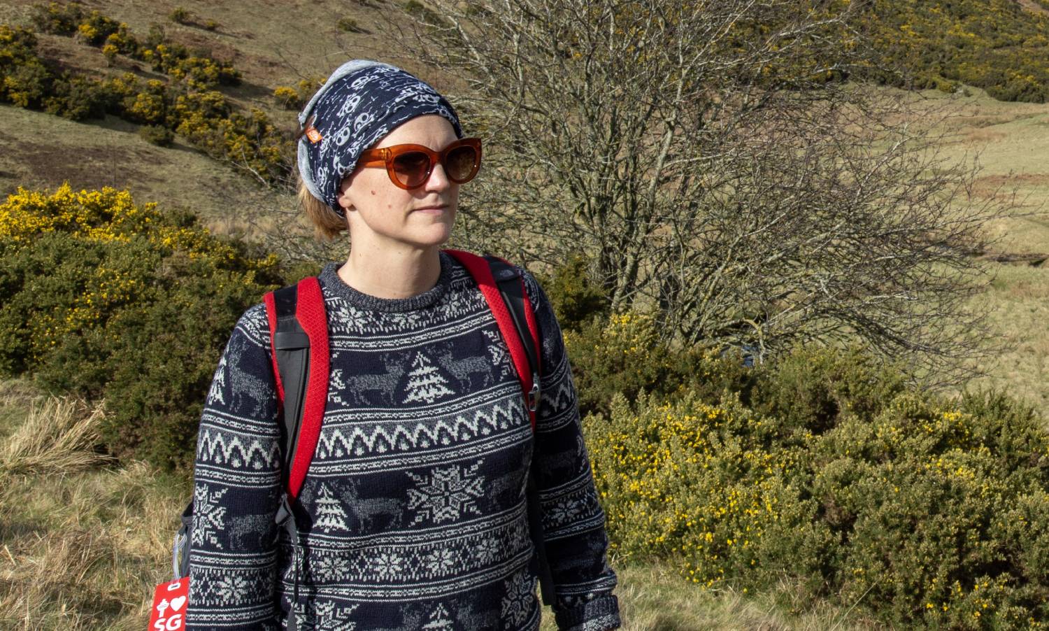 A person hiking while wearing a neck gaiter or a bandana around their head.