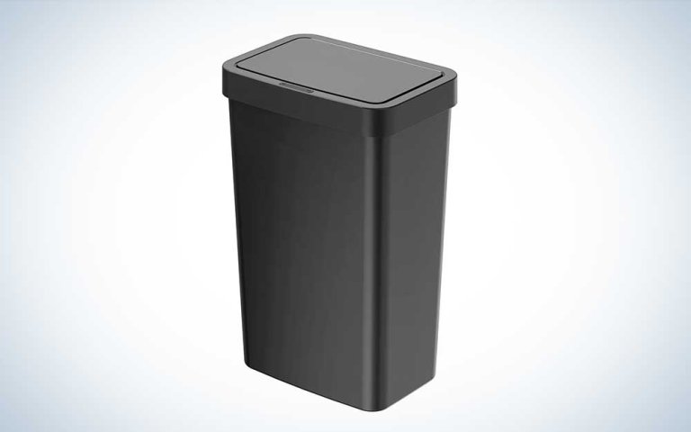 A black plastic trash can on a plain background.