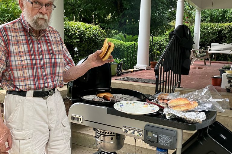 The managing editor's father posing with food fresh off his new Weber Performer Deluxe charcoal grill
